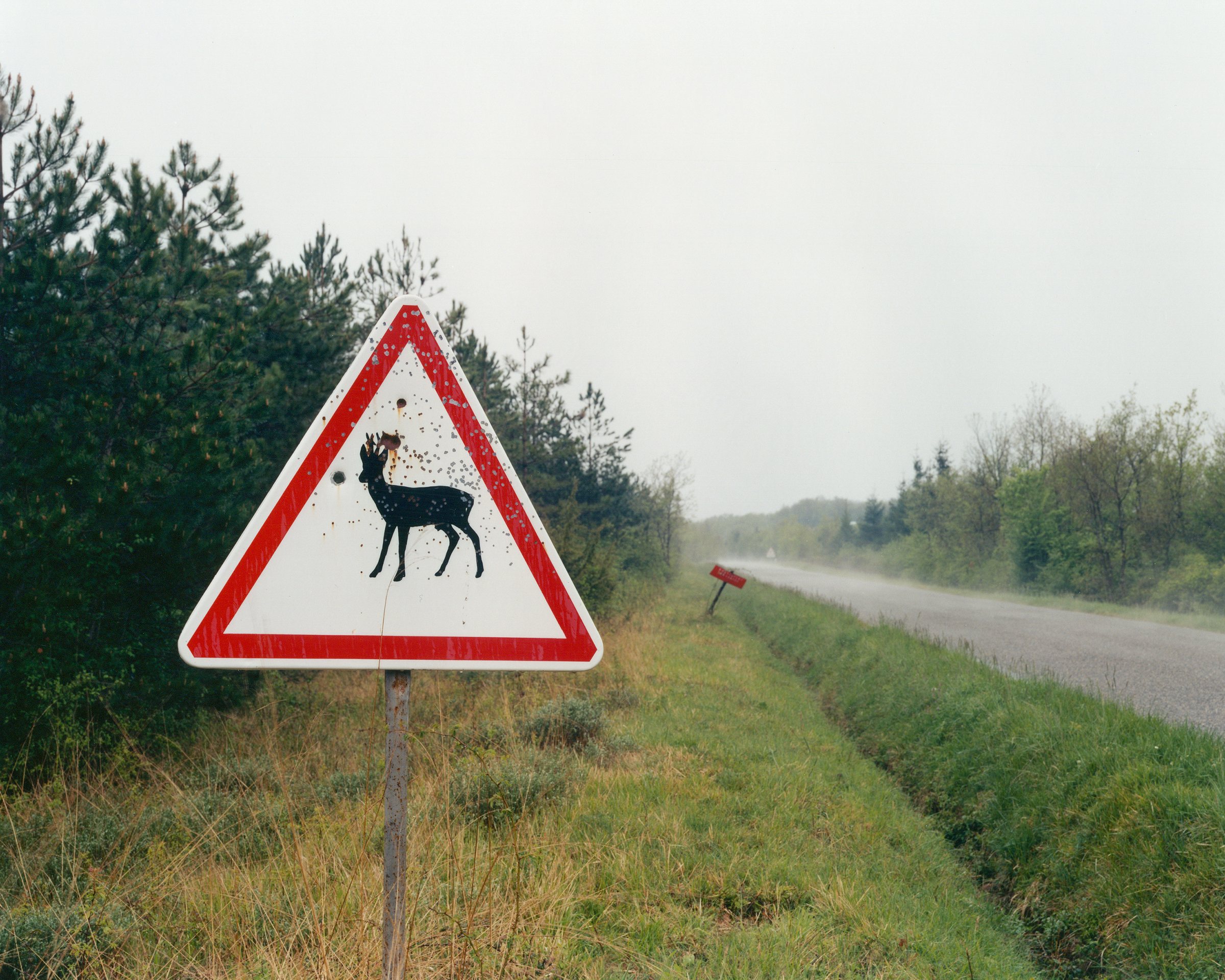 Hexagone 2 — The Landscape Consumed — Traffic sign used as a target by hunters, Gers, 2003